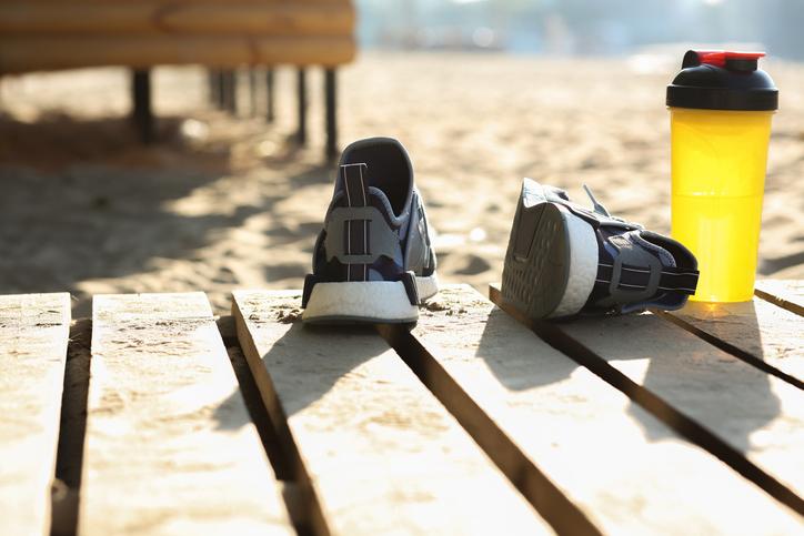 Trainers and a water bottle lie abandoned on a beach