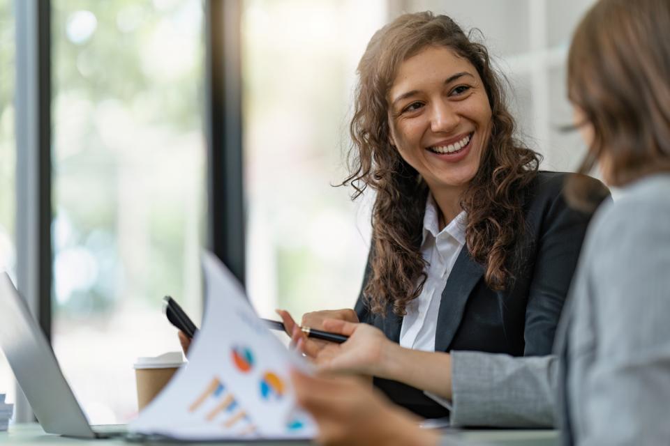 Female accountange speaking to a colleague in an office