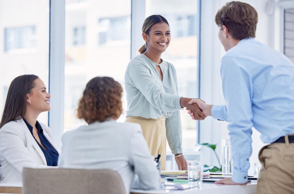 A woman shaking hands with her new employee