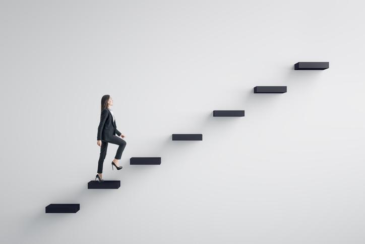 A woman walks up a floating set of stairs