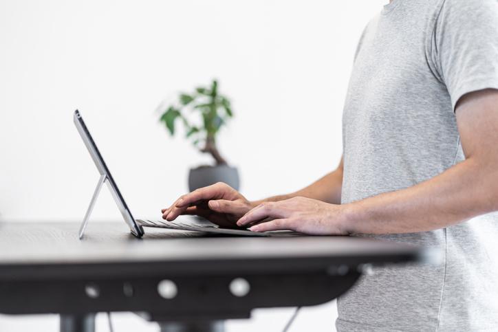 Man using a standing desk to work