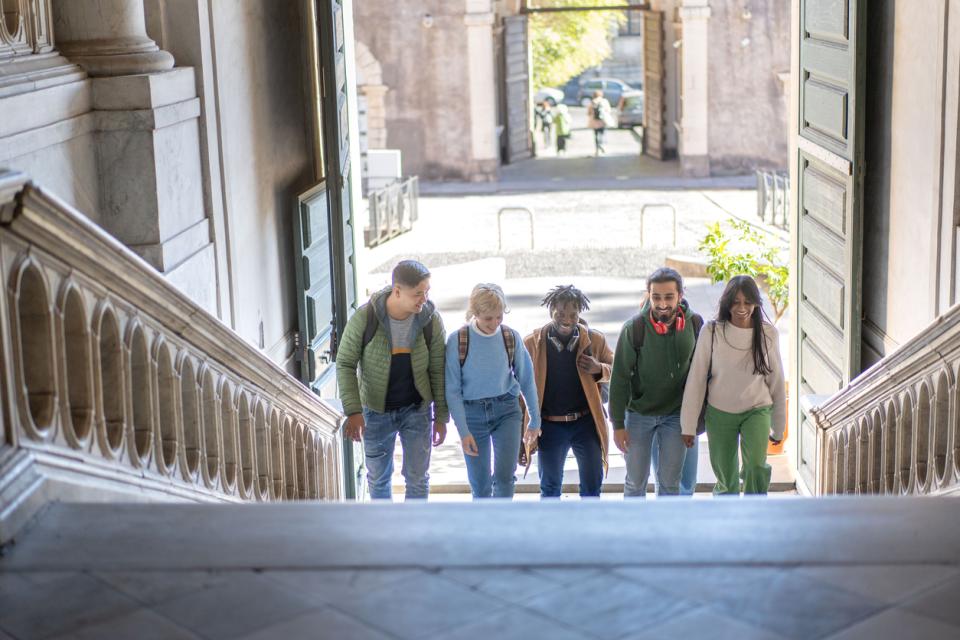 Students walking up a staircase in an old university building