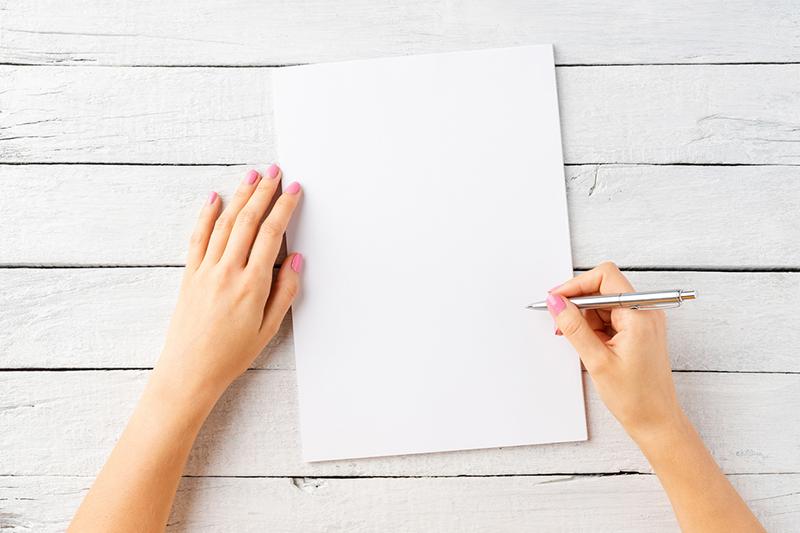 Female hands with a pen and a blank page