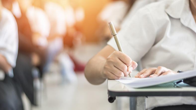 A student uses a pen to take a test