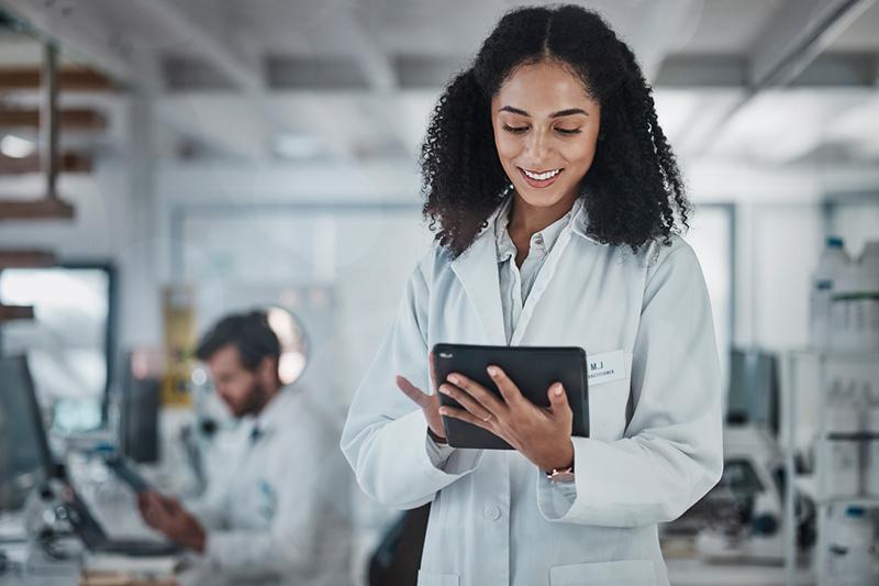 Young woman in lab coat with tablet