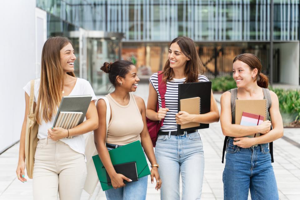 Students standing and chatting outside of a campus building