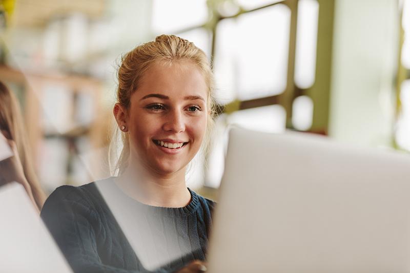 Young student smiling with laptop