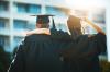 Multi-racial students walking arm in arm on graduation day