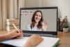 A young woman presents on a screen as someone takes notes