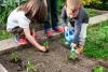 Children plant and water growing plants