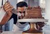 Man putting icing on a chocolate cake